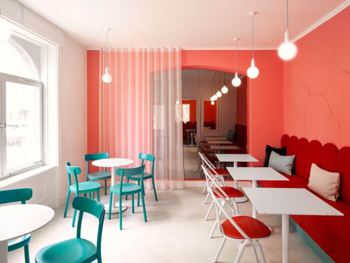 Raumgestaltung mit Durchblick: Architektonisch betonte B&ouml;gen schaffen eine optische Trennung der Gastr&auml;ume. Die Innenarchitektur nutzt hohe Decken und wei&szlig;e Fensterrahmen, um die Intensit&auml;t der Farben auszubalancieren und Licht zu maximieren