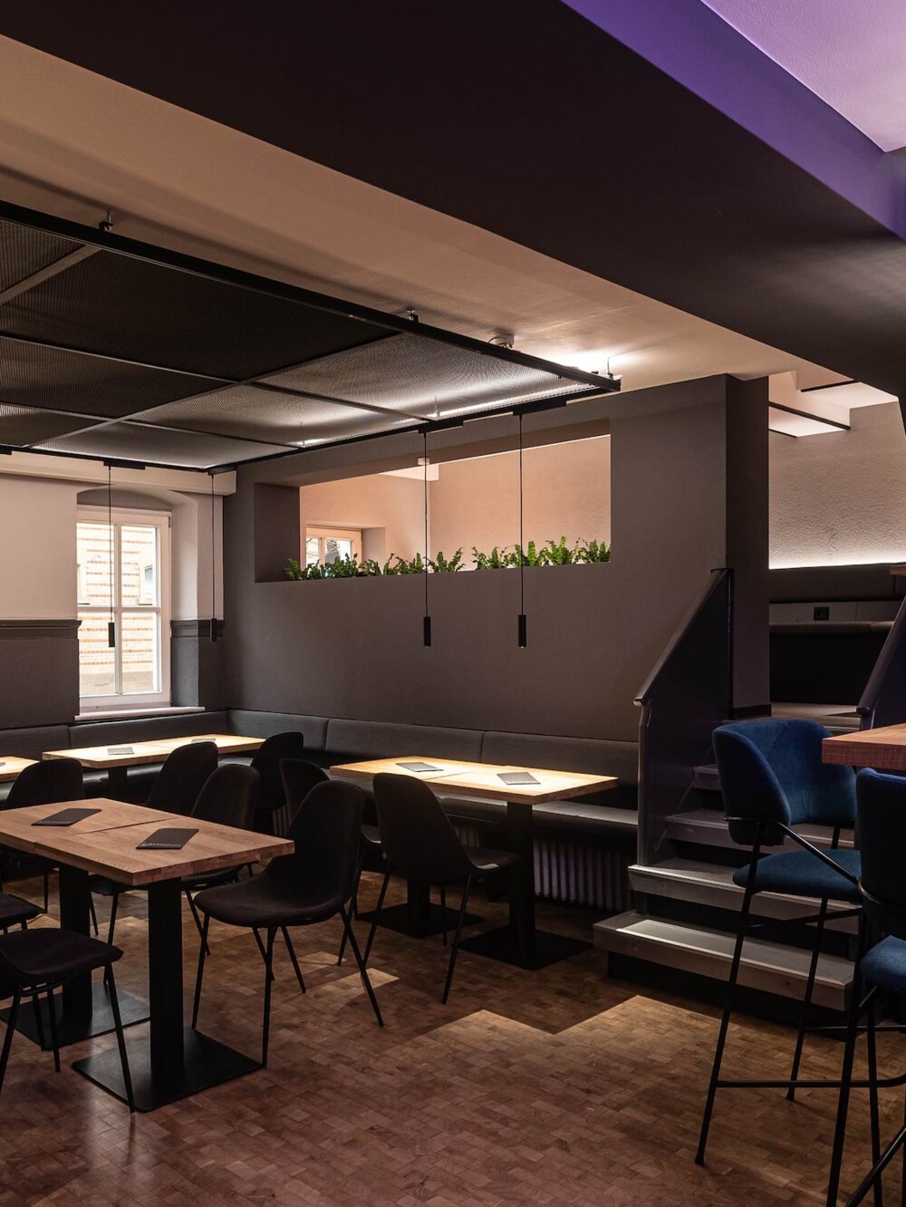 Gastronomie-Einrichtung Ludwigsburg &ndash; moderner Gastraum der Gaunerei mit dunkler M&ouml;blierung und Holzboden, Entwurf und Realisierung in der Region Stuttgart.