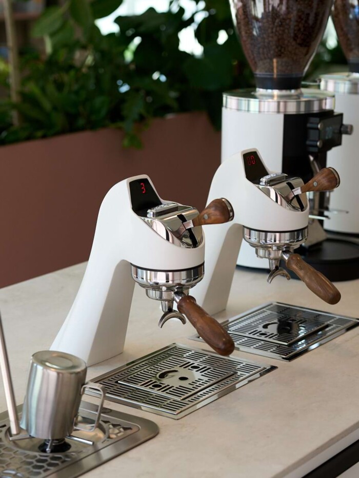 Exzellentes Schreinerhandwerk an der Theke: Die Verkleidung der Bar mit vertikalen Holzlamellen. Das Werkkollektiv realisierte die Funktionstheke mit integriertem Barista-Arbeitsplatz und hellen Stein-Arbeitsfl&auml;chen