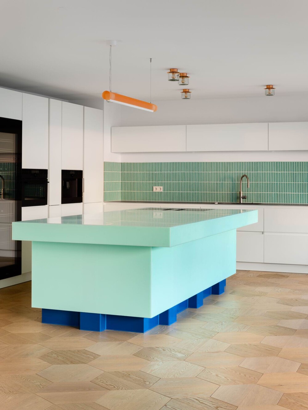 Individuelle K&uuml;chenplanung und Umsetzung aus einer Hand &ndash; ma&szlig;gefertigte K&uuml;cheninsel mit mintgr&uuml;ner Arbeitsfl&auml;che und blauem Sockel, realisiert vom Werkskollektiv.