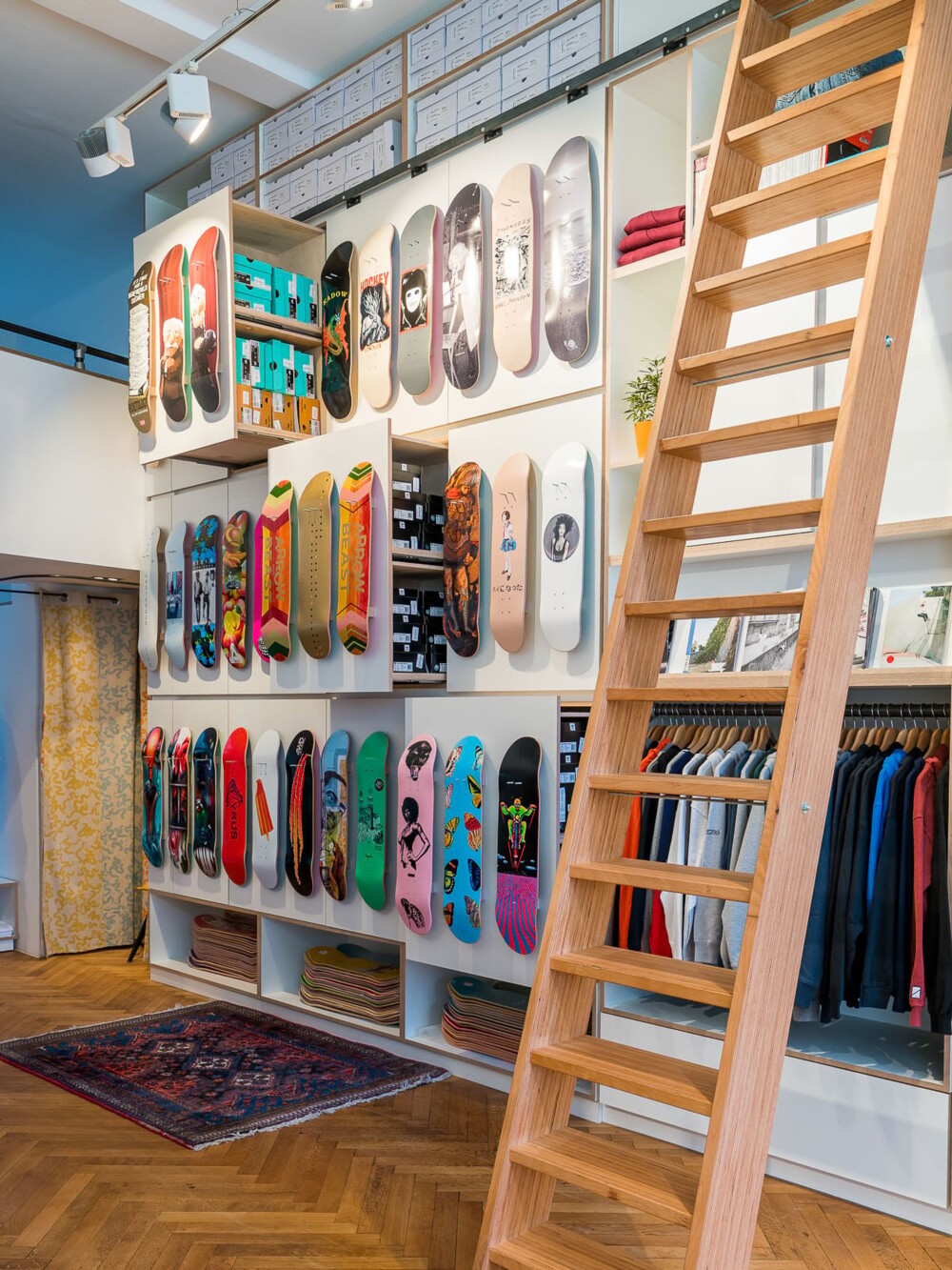 Shop-Design f&uuml;r Skateshop in Stuttgart &ndash; funktionale Pr&auml;sentation von Skateboards mit Holzleiter und flexiblen Wandsystemen, realisiert aus einer Hand.