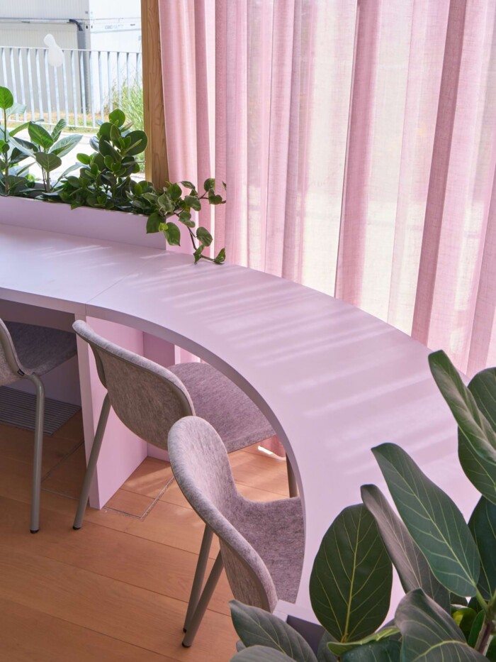 Sonderanfertigung Sitzm&ouml;bel: Geschwungener, ma&szlig;gefertigter Hochtisch aus hellem Material. Das Stuttgarter Werkkollektiv setzte diese organische Konstruktion um, erg&auml;nzt durch lichtdurchl&auml;ssige Vorh&auml;nge